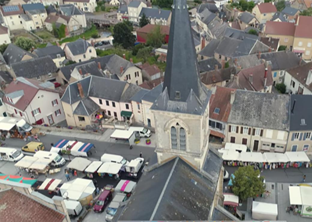 Vue du ciel, le clocher d'une église et des étals de marché