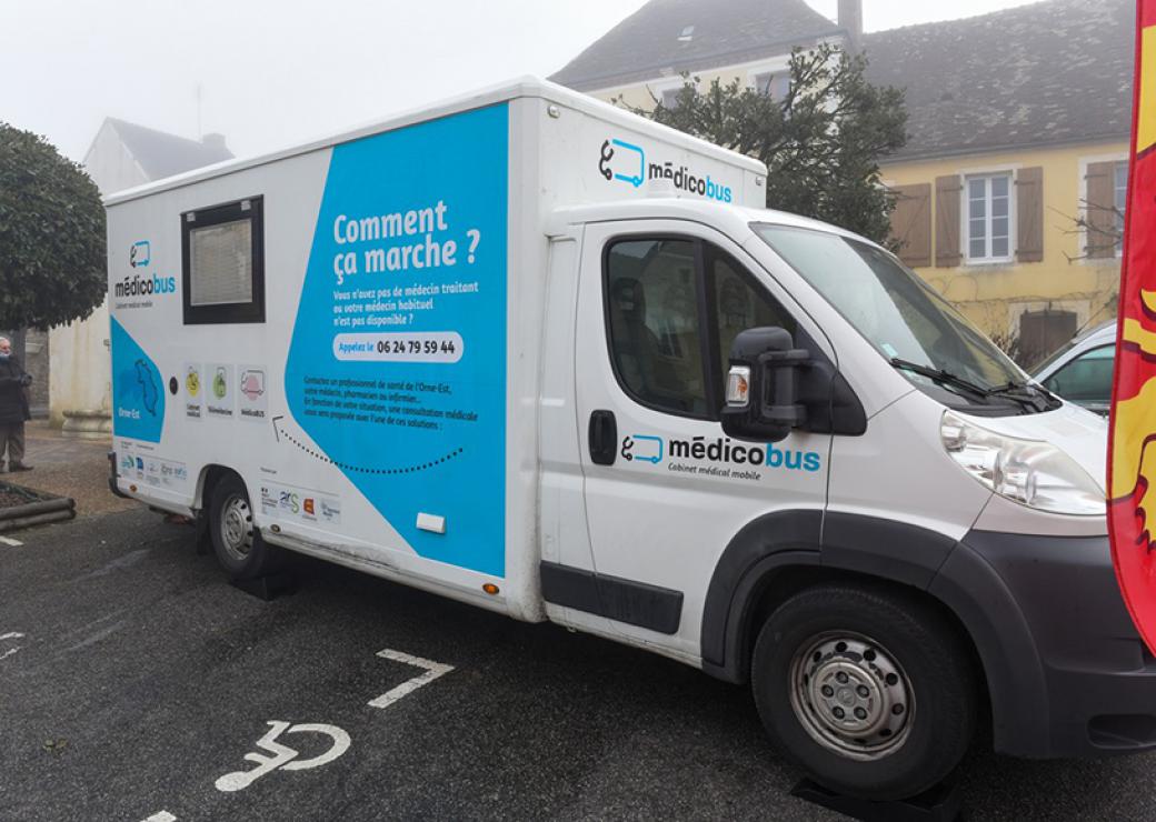 Un camion sur lequel est écrit medicobus est garé sur la place d'un village