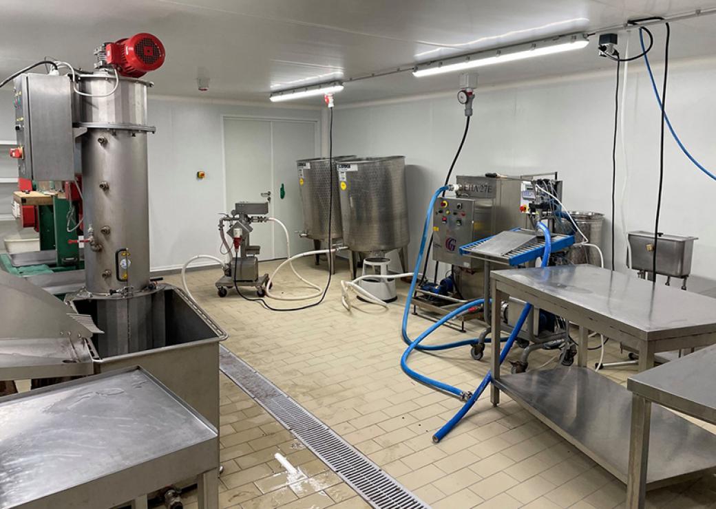 Photo d'un labo de cuisine avec de grandes machines en inox, éclairé par deux néons