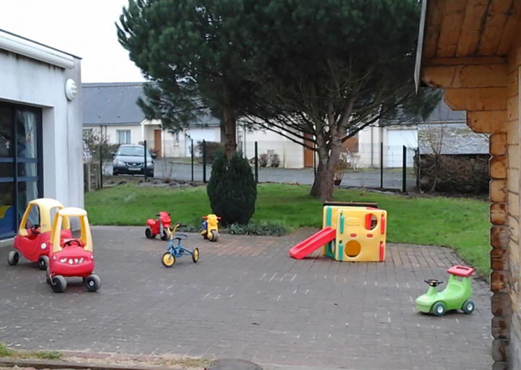 Cours d'une crèche: auto miniatures, toboggan et tricycles