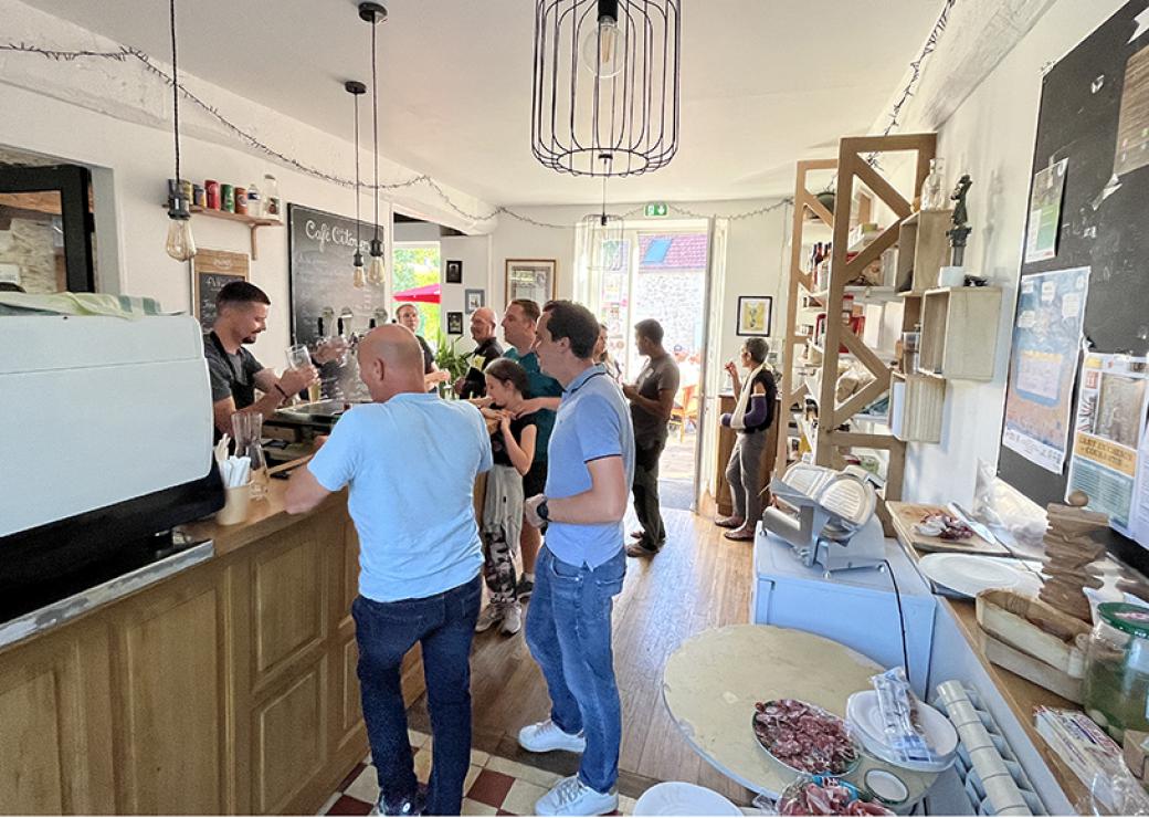 À l'intérieur d'un café, des personnes sont accoudées au bar