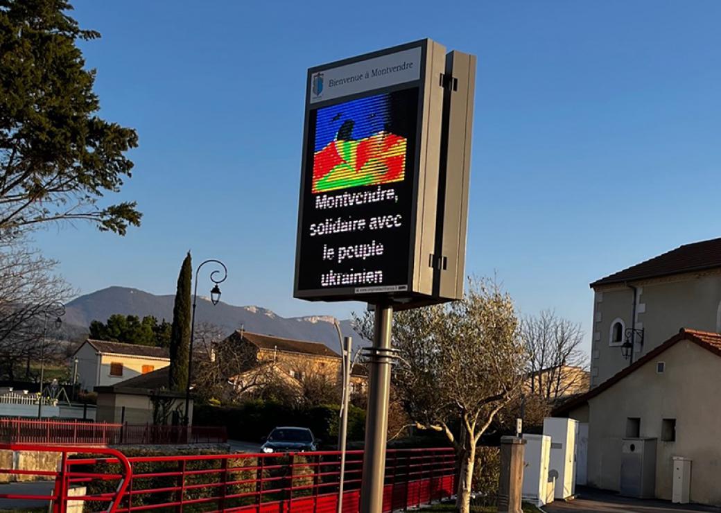 Photo d'un panneau numérique installé dans un village. On peut lire "Bienvenue à Montvendre", "Montvendre solidaire avec le peuple ukrainien