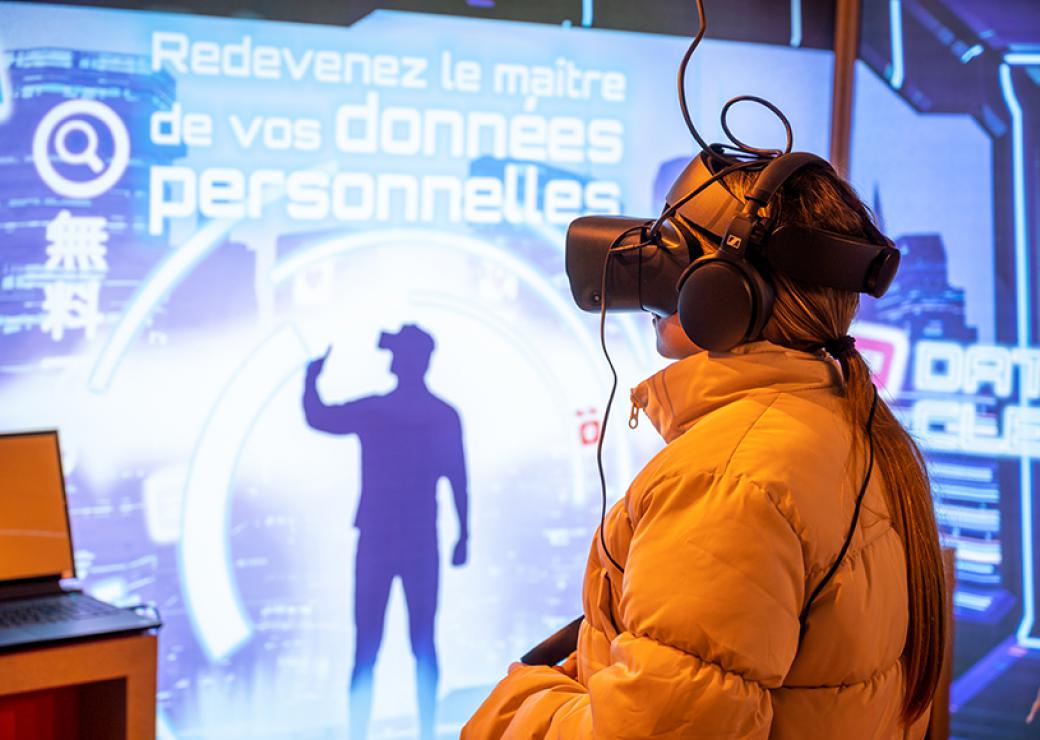 devant un écran sur lequel on peut lire "redevenez maitre de vos données personnelles", se tient une personne équipée d'un casque sur les yeux et les oreilles