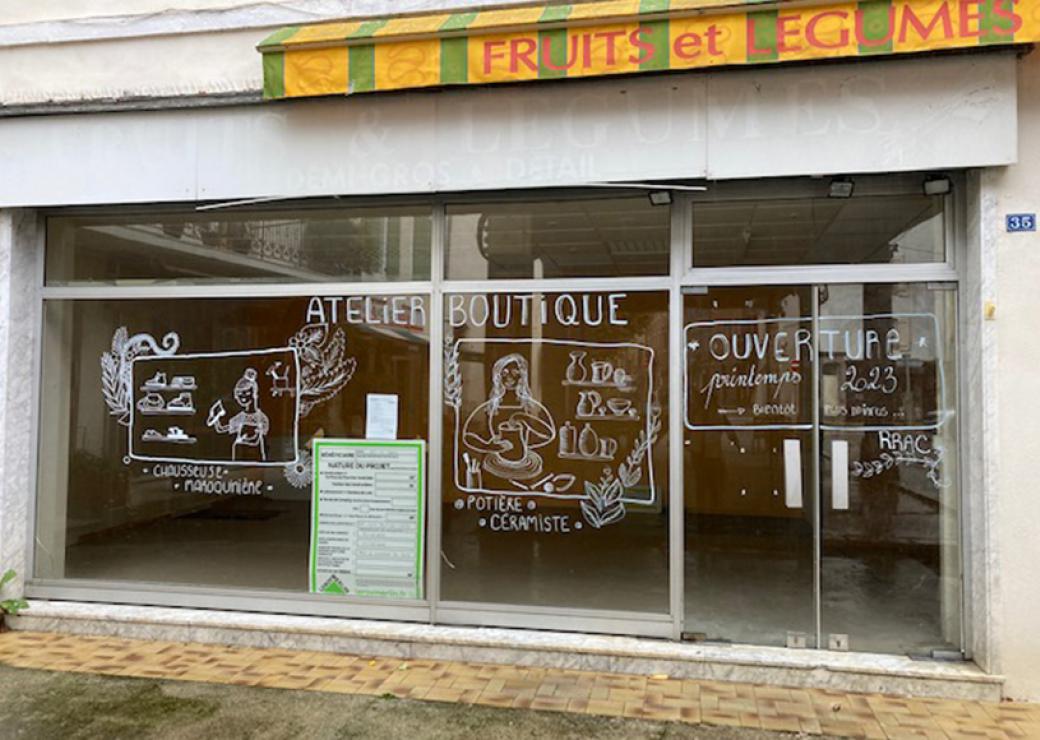 Photo d'une vitrine sur laquelle on peut lire "atelier boutique", accompagné de dessins