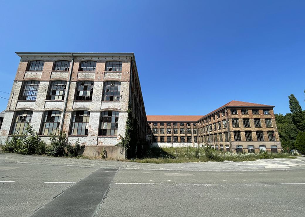 Un batiment industriel du XIXeme siècle, en briques rouges, larges ouvertures