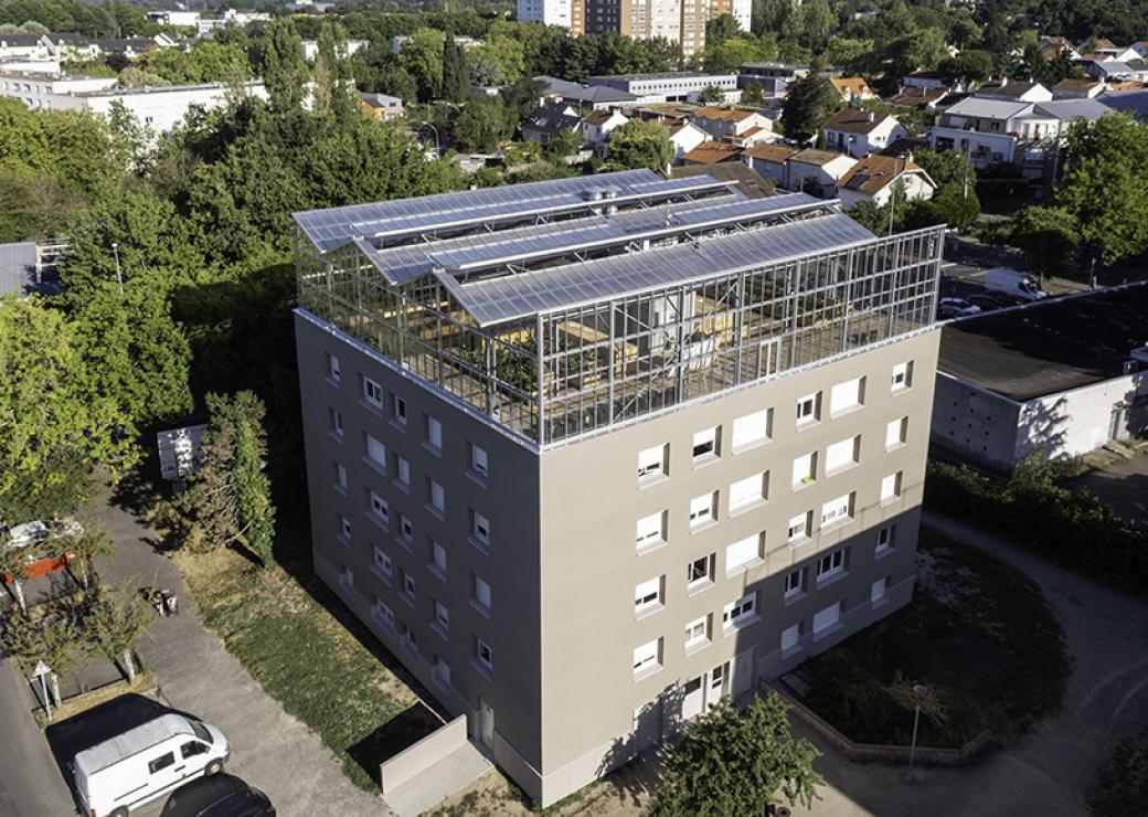 Vue du ciel d'un bâtiment carré surmonté d'une serre