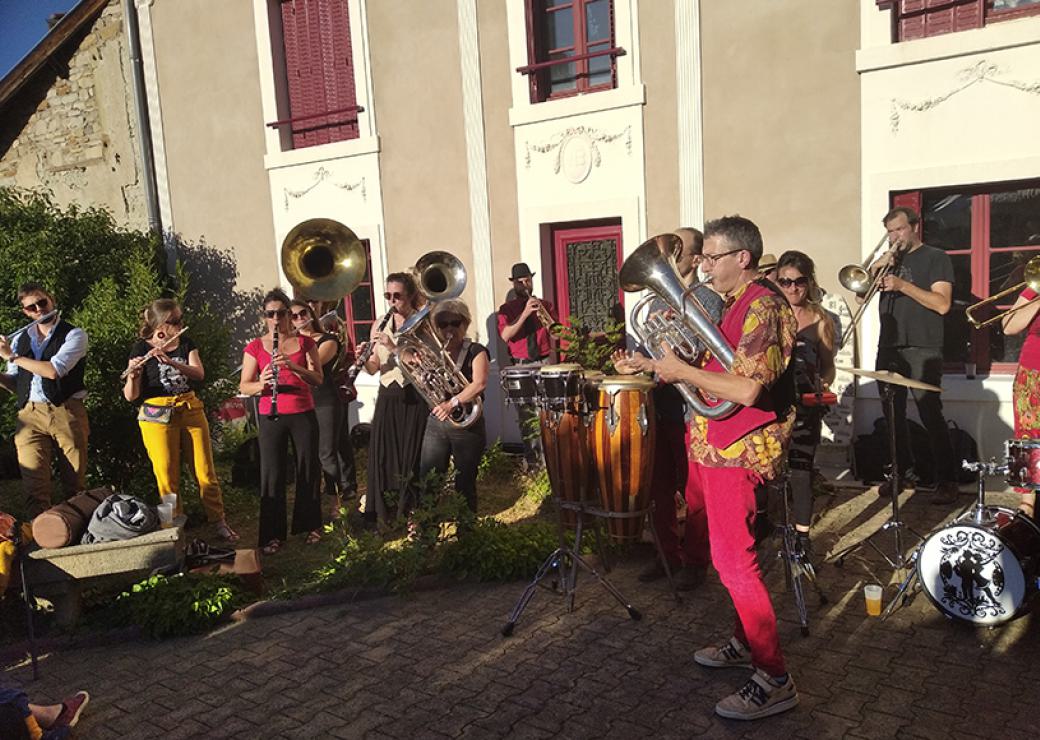 Devant la jolie façade d'une maison, une fanfare joue