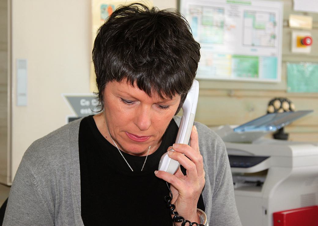 Une femme dans son bureau répondant au téléphone 