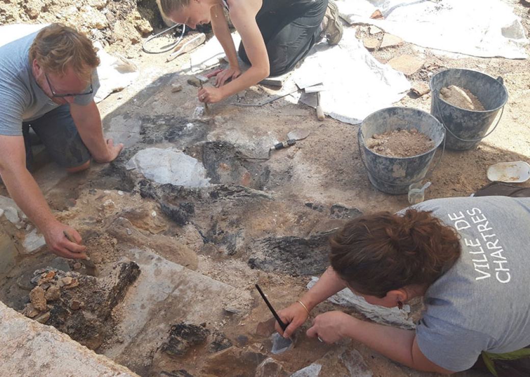 Vues d'en haut, trois personnes travaillent sur un site de fouilles archéologiques