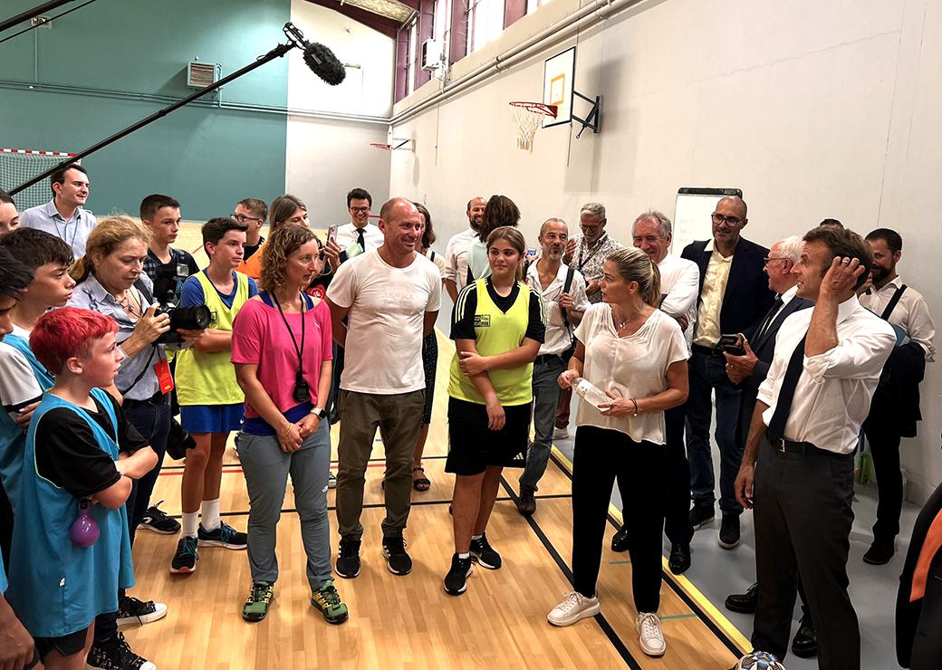 Emmanuel Macron au gymnase du collège discutant avec la professeure de sport