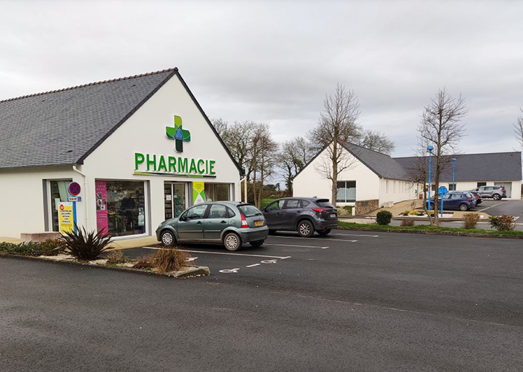 Bâtiment où l'on peut lire pharmacie sur le fronton, entouré d'un parking