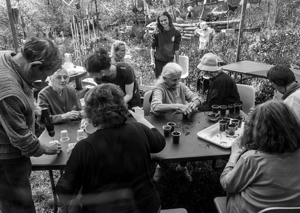 Photo en noir et blanc de personnes attablées en extérieur