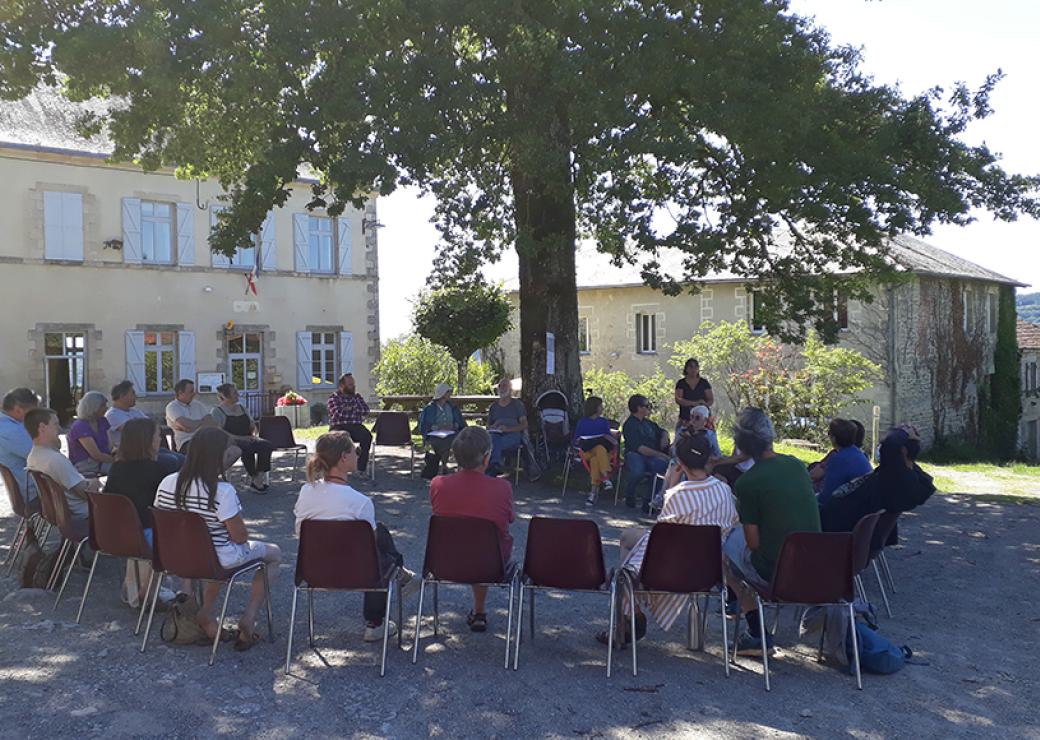 Des personnes assises en cercle sous un arbre