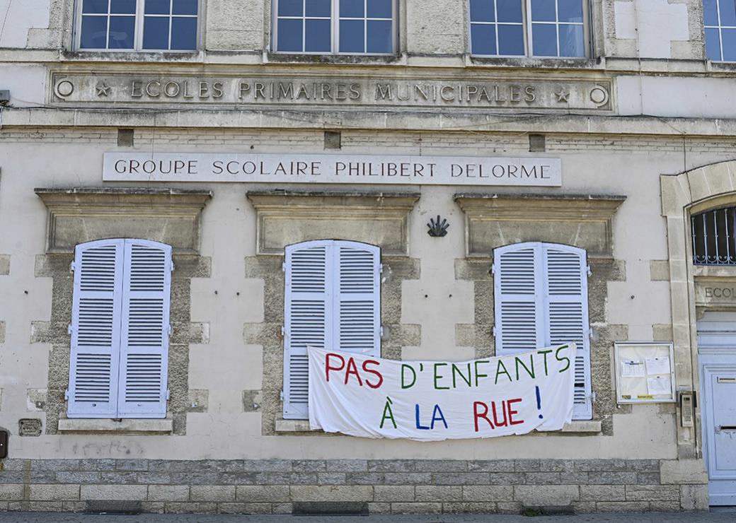 banderole "pas d'enfants à la rue " sur une façade d'école 