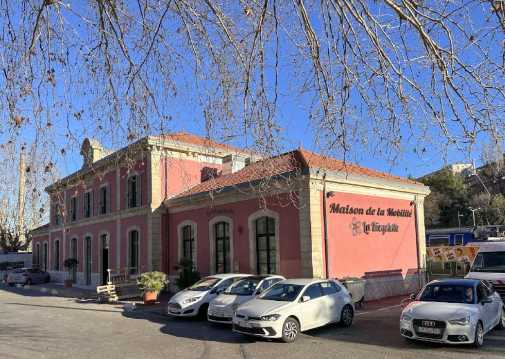 Bâtisse peinte en rose sur laquelle on peut lire "Maison de la mobilité"