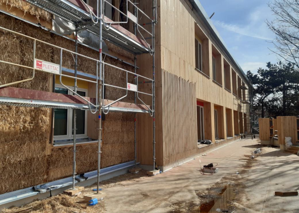 Un bâtiment en construction, bardé de bois