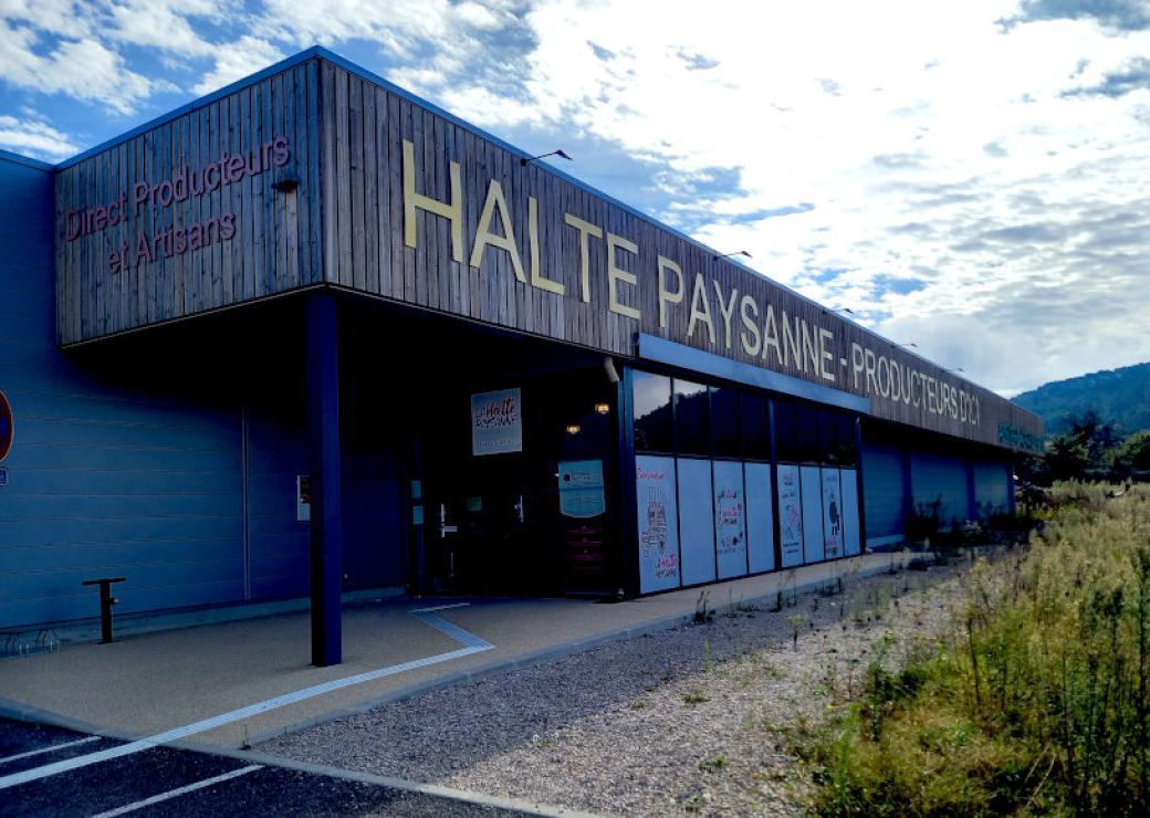 Bâtiment type hangar sur lequel on peut lire "halte paysanne - producteur"