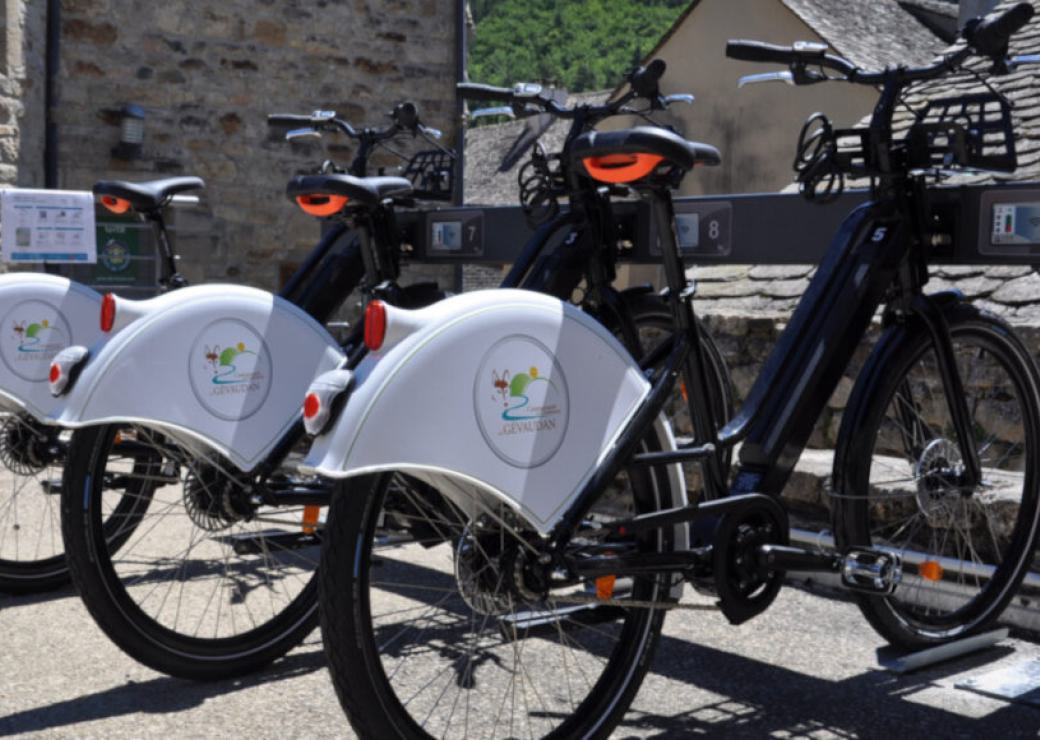 Vélos sur un parking à vélos près d'un muret de pierres sèches