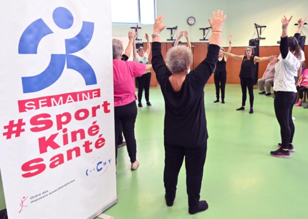 Des femmes en habit de gymnastiques se tiennent en cercle, bras levés vers le ciel