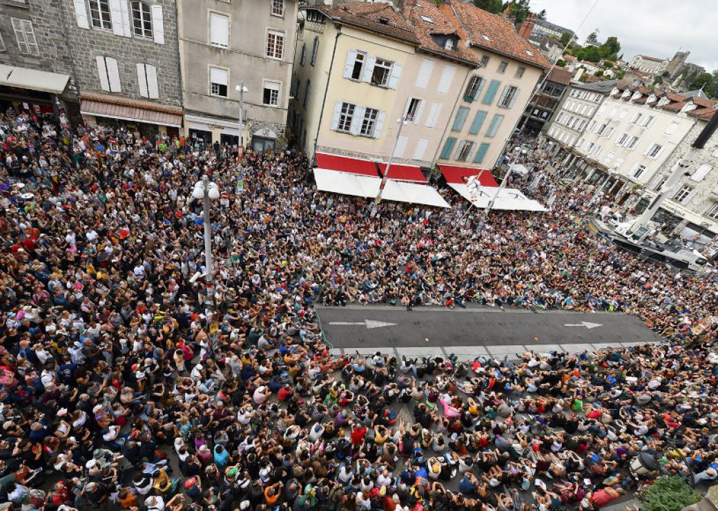 Vue aérienne d'une rue remplie de gens assis sur le sol, autour d'une portion de rue dégagée