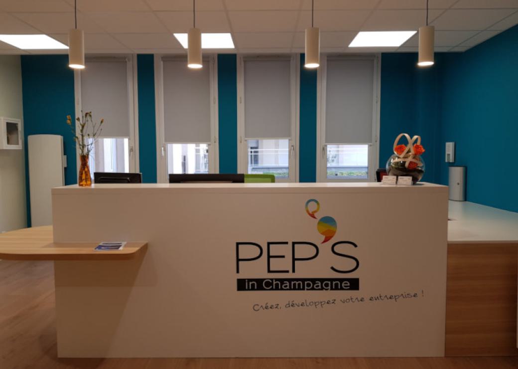 Vue sur une banque d'accueil sur laquelle on peut lire "pep's in champagne"