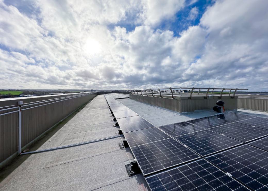 Toiture recouvertes de panneaux solaires sous ciel de nuages cotonneux