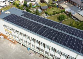 Vue du ciel d'une école dont le toit est couvert de panneaux photovoltaïques