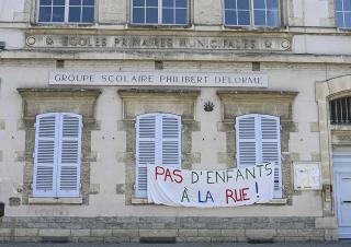 banderole "pas d'enfants à la rue " sur une façade d'école 